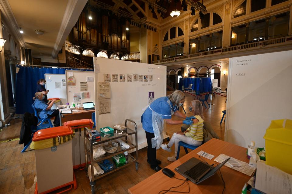 A health worker injects a dose of the AstraZeneca/Oxford Covid-19 vaccine at a temporary vaccine centre set up at City Hall in Hull, northeast England on May 7, 2021. (Photo by Oli SCARFF / AFP) (Photo by OLI SCARFF/AFP via Getty Images)