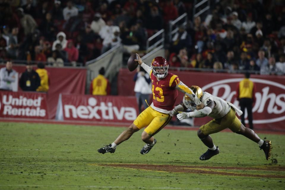 USC quarterback Caleb Williams evades Notre Dame defensive back Justin Ademilola in the fourth quarter Nov. 26, 2022.