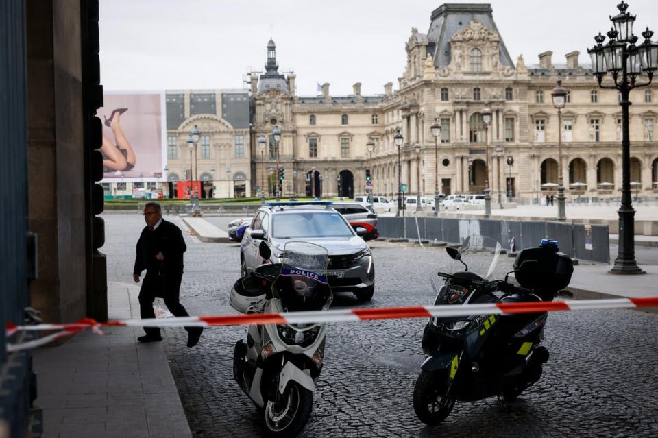 Police officers stand guard outside the Louvre Museum (AP)