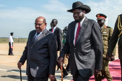 South Sudan President Salva Kiir (R) walks with Sudan's President Omar al-Bashir (L) ahead of a Juba airport ceremony to welcome the latest peace accord for the war-ravaged south