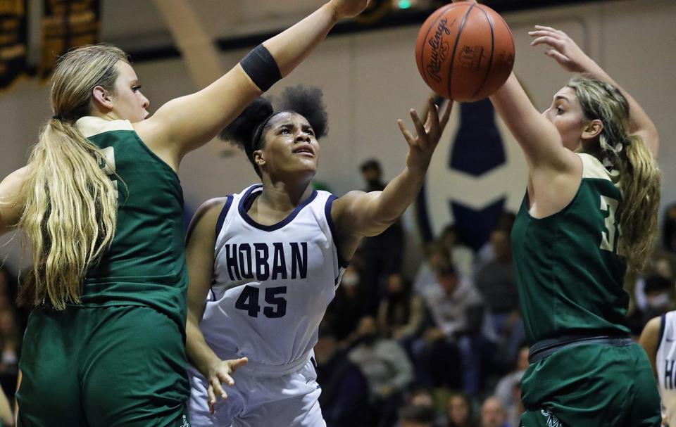 Hoban's Lanae Riley, center, shoots a layup between STVM's Jenna Bycznski, left, and Cameron Jones during her senior season.