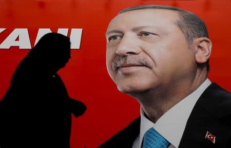 A woman passes by an election poster of Turkey's President Tayyip Erdogan in Istanbul, Turkey June 23, 2018. REUTERS/Alkis Konstantinidis