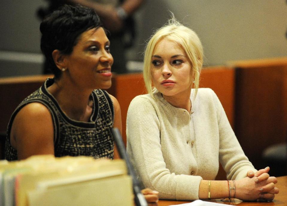 FILE - In this Dec. 14, 2011 file photo, Lindsay Lohan, right, alongside her attorney Shawn Chapman Holley appear during a progress report session at the Los Angeles Superior Court, in Los Angeles. A star of Disney films whose acting received early praise and attention, Lohan’s 2007 two arrests for DUI and drug possession still haunts the actress today. While the 27-year-old has put those cases behind her, she remains on probation for a necklace theft case and lying to police about her role in a crash on Pacific Coast Highway. (AP Photo/Michael Nelson, Pool, File)