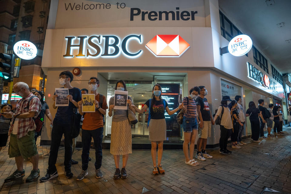 HONG KONG, CHINA - 2019/08/23: Protesters form a human chain in front of a HSBC bank branch. Thousands of Hong Kong protesters link hands to form human chain across the city to call for democracy during the Hong Kong way event. The chains, which traced three subway routes, totaled around 40 kilometers (25 miles) in length. The protesters said they were inspired by the "Baltic Way', when millions created a chain across three countries (Estonia, Latvia and Lithuania) to protest Soviet occupation exactly 30 years ago, and is the latest in the nearly 11-week-old movement that began with calls to scrap a now-suspended extradition bill and has broadened to include demands for full democracy and an independent inquiry into alleged police brutality. (Photo by Geovien So/SOPA Images/LightRocket via Getty Images)