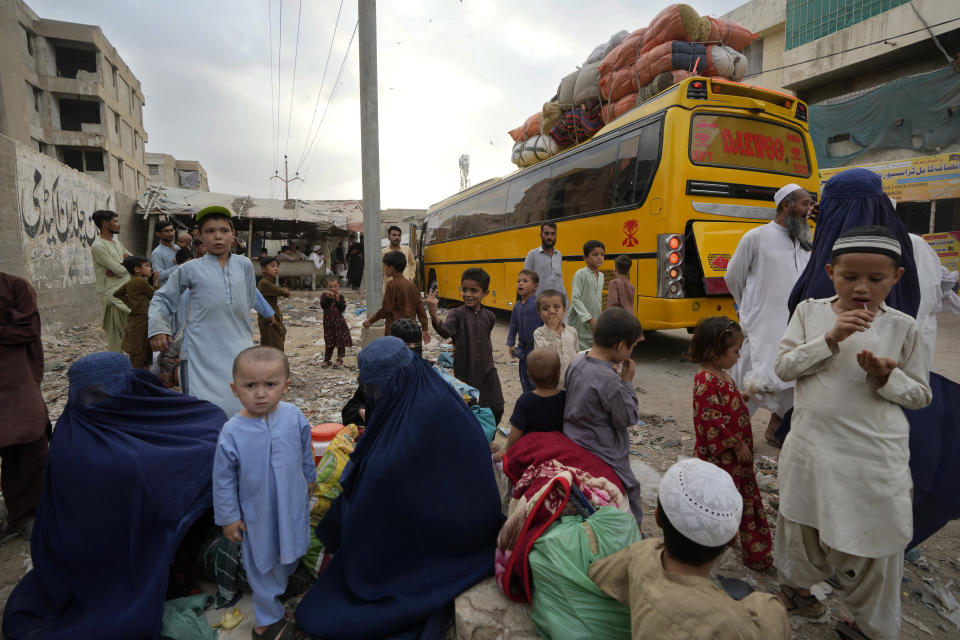 Familias afganas esperan abordar un autobús para partir hacia su patria, en Karachi, Pakistán, el viernes 6 de octubre de 2023. (AP Foto/Fareed Khan)