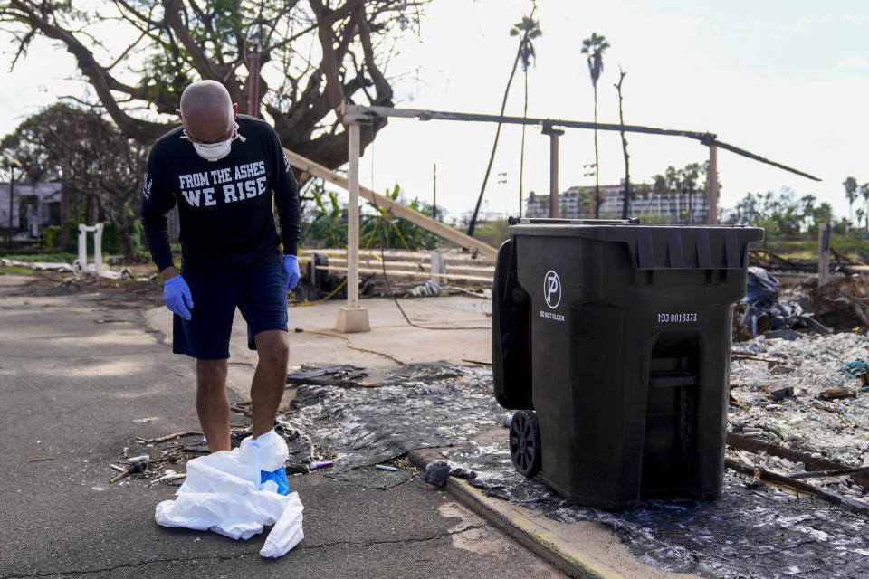 Rev. Ai Hironaka, resident minister of the Lahaina Hongwanji Mission, takes off protective equipment after walking through his temple and residence destroyed by wildfire, Thursday, Dec. 7, 2023, in Lahaina, Hawaii. Recovery efforts continue after the August wildfire that swept through the Lahaina community on Hawaiian island of Maui, the deadliest U.S. wildfire in more than a century. (AP Photo/Lindsey Wasson)