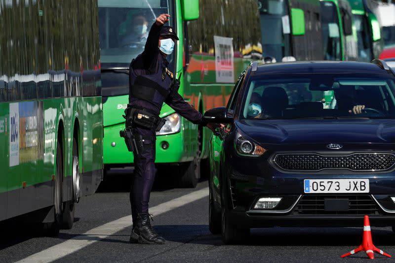 FOTO DE ARCHIVO: Un agente de la Policía Nacional con una mascarilla se dirige a los ocupantes de un vechículo en Madrid