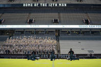 The Texas A&M University Yell Leaders kneel at midfield as part of the first Midnight Yell Practice this season in Kyle Field, College Station, Texas early Saturday, Sept. 26, 2020. . Due to Coronavirus restrictions, the Texas A&M Band were the only crowd allowed in the normally packed stands for the traditional game day event in College Station, Texas. (Sam Craft/Pool Photo via AP)