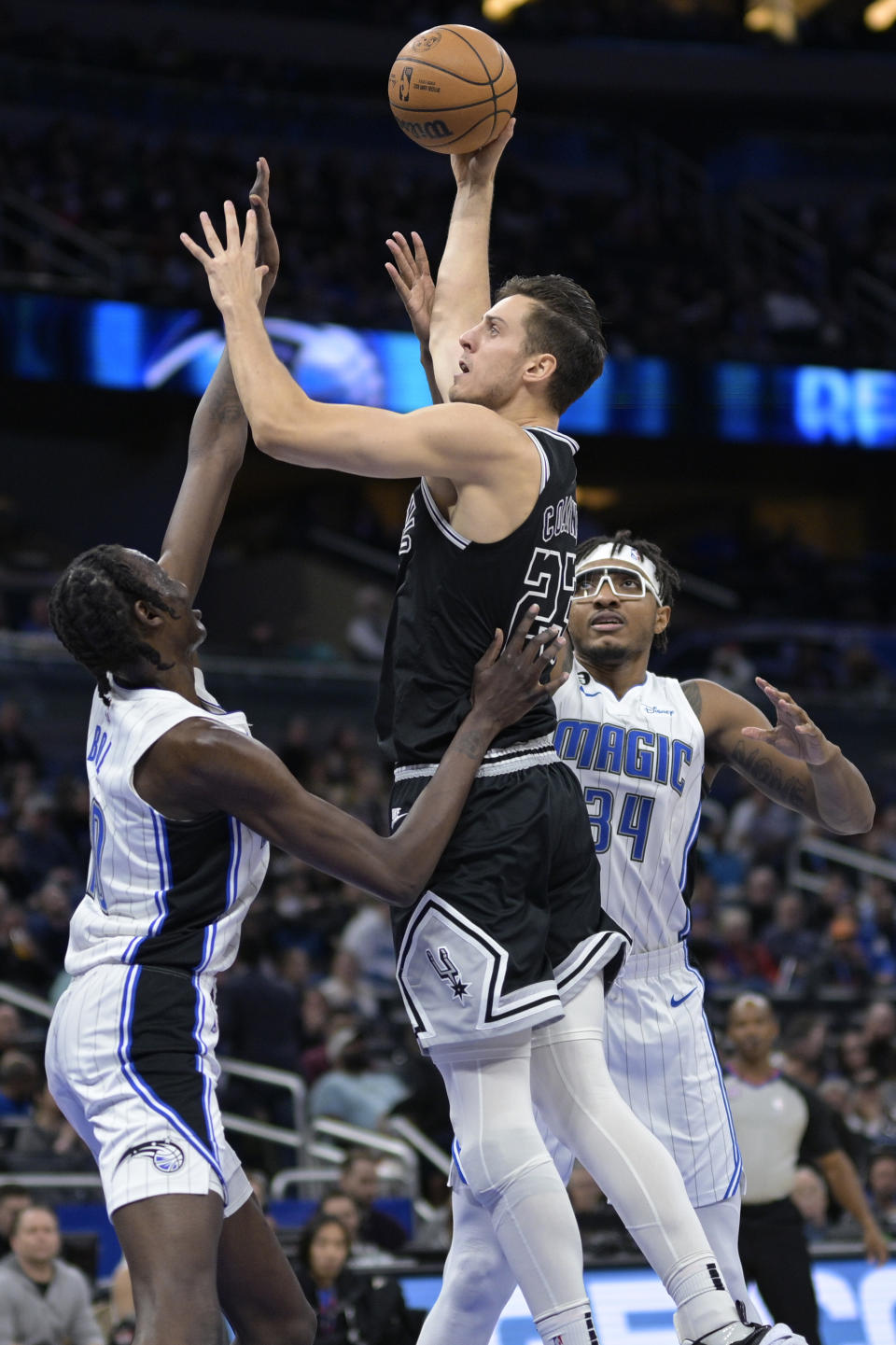 San Antonio Spurs forward Zach Collins (23) goes up for a shot between Orlando Magic center Bol Bol (10) and center Wendell Carter Jr. (34) during the first half of an NBA basketball game Friday, Dec. 23, 2022, in Orlando, Fla. (AP Photo/Phelan M. Ebenhack)