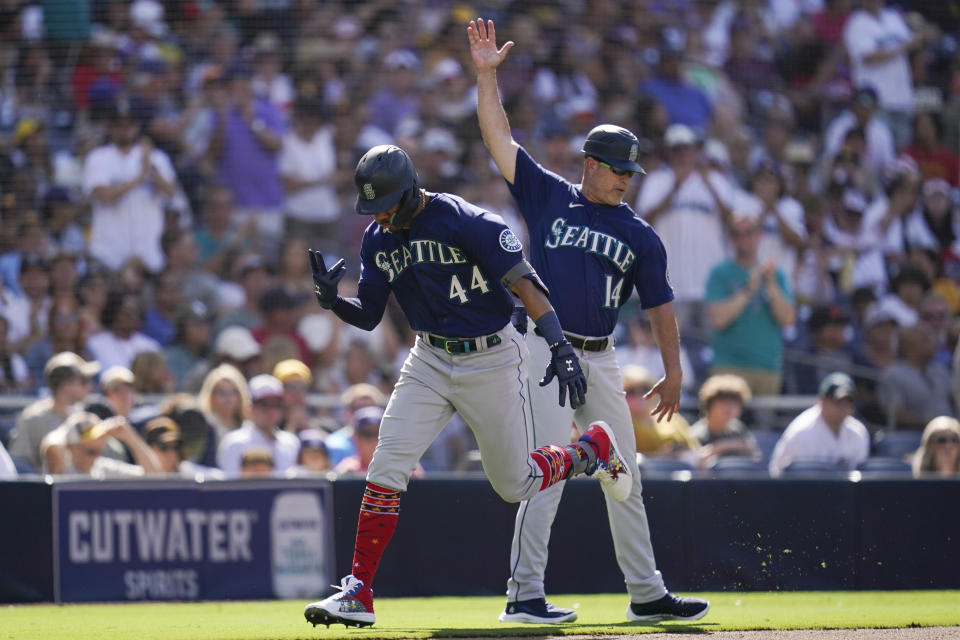Seattle Mariners' Julio Rodriguez, left, reacts with third base coach Manny Acta after hitting a two-run home run during the fourth inning of a baseball game against the San Diego Padres, Monday, July 4, 2022, in San Diego. (AP Photo/Gregory Bull)