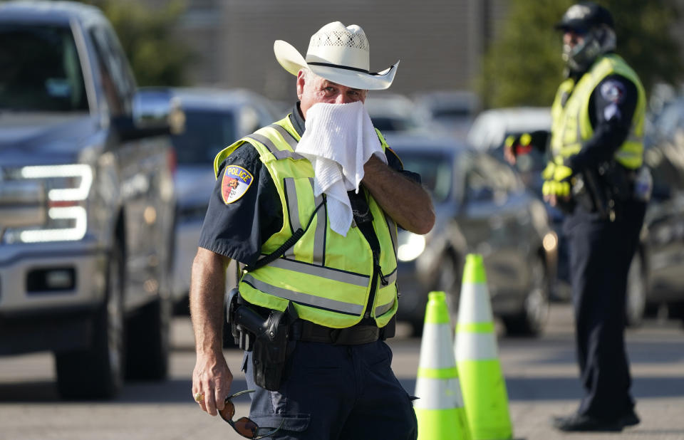 Police officer James Rhodes uses a wet towel to cool off as he directs traffic after a sporting event in Arlington, Texas, Saturday, Aug. 19, 2023. The summer of 2023 may be drawing to a close — but the extreme heat is not: More record-shattering temperatures — this time across Texas — are expected Saturday and Sunday as the U.S. continues to bake. (AP Photo/LM Otero)
