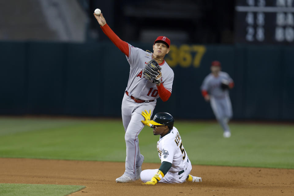 Los Angeles Angels shortstop Gio Urshela (10) throws to first as Oakland Athletics' Tony Kemp (5) slides into second on a fielder's choice hit by Conner Capel in the first inning of an opening day baseball game in Oakland, Calif., Thursday, March 30, 2023. (AP Photo/Jed Jacobsohn)