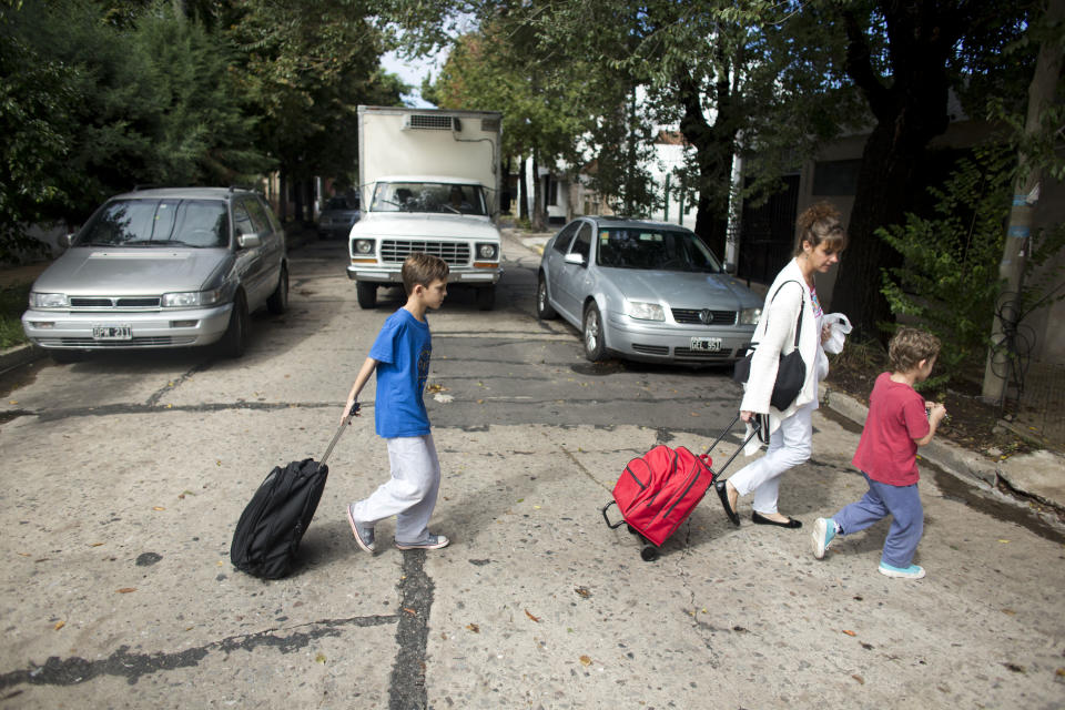 In this April 8, 2014 photo, Maria Eugenia Diez walks her sons, Facundo, left, and Felipe, right, from school in Buenos Aires, Argentina. On Thursday, April 10, 2014, a nationwide strike paralyzed Argentina’s public transportation, all non-emergency hospital attention and other sections of public life. Diez, a middle-class housewife, says she's sympathetic to the union workers' salary woes and supports many of the government's efforts to direct resources to the poor, but thinks the strike just takes more money from everyone's pockets. (AP Photo/Victor R. Caivano)