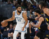 Minnesota Timberwolves center Karl-Anthony Towns, left, looks to drive to the basket as Denver Nuggets guard Jamal Murray, center, and forward Aaron Gordon defend in the first half of Game 7 of an NBA second-round playoff series against the, Sunday, May 19, 2024, in Denver. (AP Photo/David Zalubowski)