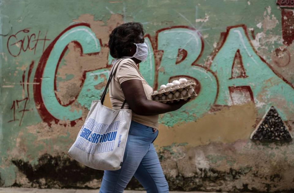 Una mujer carga cartones de huevos en La Habana Vieja, Cuba, el martes 27 de octubre de 2020.