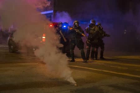 Police in riot gear stand guard after deploying tear gas to disperse protesters in Ferguson, Missouri November 25, 2014. REUTERS/Adrees Latif