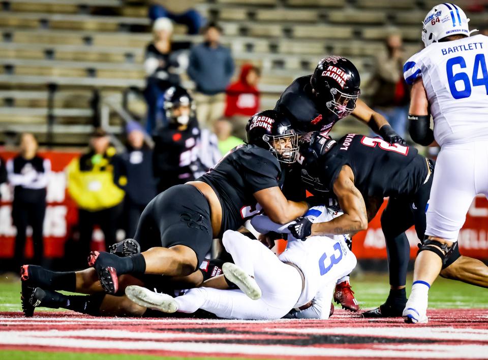 UL defensive lineman Tayland Humphrey (left), linebacker Ferrod Gardner and linebacker Lorenzo McCaskill (right) team up to make a stop against Georgia State earlier this season at Cajun Field.