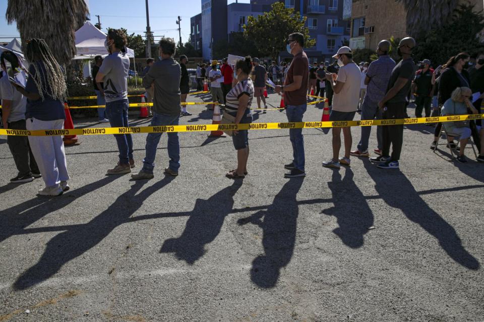 People wait in line to get vaccinated against monkeypox at a St. John's Community Health site in Los Angeles.