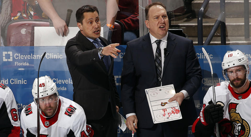 Guy Boucher (left) and Martin Raymond (right) behind the bench for the Ottawa Senators. (Getty Images)
