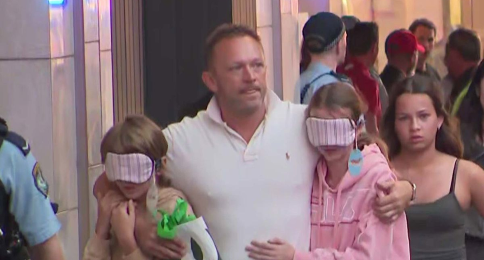 A father and his blindfolded children.