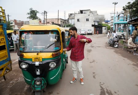 Danish Maqbool Malik pays to an auto rickshaw driver upon reaching at a railway station after meeting his brother Uzair Maqbool Malik in a central jail, in Agra
