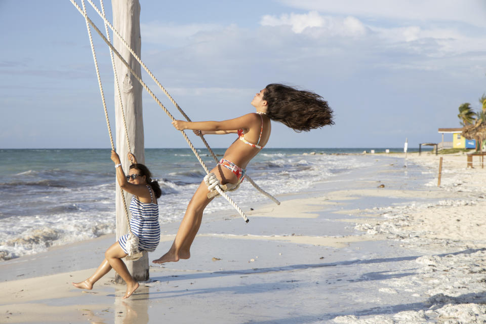 Baltimore tourists Loren Fantasia, left, and her mother, swing on the beach before the arrival of Hurricane Dorian, in Freeport, Bahamas, Friday, Aug. 30, 2019. Forecasters said the hurricane is expected to keep on strengthening and become a Category 3 later in the day. (AP Photo/Tim Aylen)
