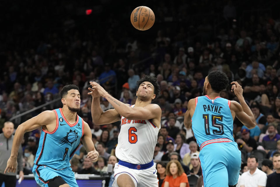 New York Knicks guard Quentin Grimes (6) gets the ball stripped by Phoenix Suns guard Cameron Payne (15) as Suns guard Devin Booker (1) avoids a collision during the first half of an NBA basketball game in Phoenix, Sunday, Nov. 20, 2022. (AP Photo/Ross D. Franklin)