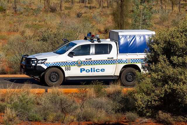 <p> Steve Christo - Corbis/Corbis via Getty</p> Northern Territory Police drive past Uluru in the Uluru-Kata Tjuta National Park