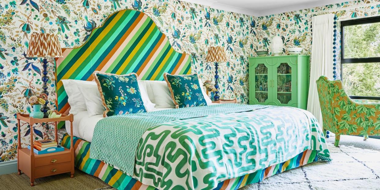 a colourful pattern clash maximalist bedroom with a bed and a chair