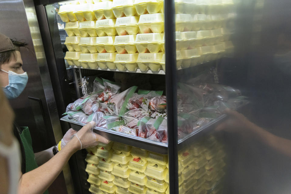 Nicholas Loud takes strawberries from a refrigerator at Community Help in Park Slope, a soup kitchen and food pantry better known as CHiPS, on Friday, June 16, 2023 in New York. Charitable giving in the United States declined in 2022. The downturn in giving has led to issues at CHiPS, as it has in many charities across the country. (AP Photo/Jeenah Moon)