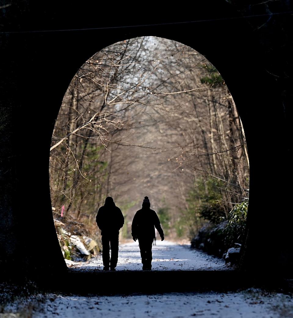 Walkers pass through the Phipps Tunnel on the Holliston Rail Trail, Dec. 9, 2021.  The area is part of the Upper Charles Rail Trail.  