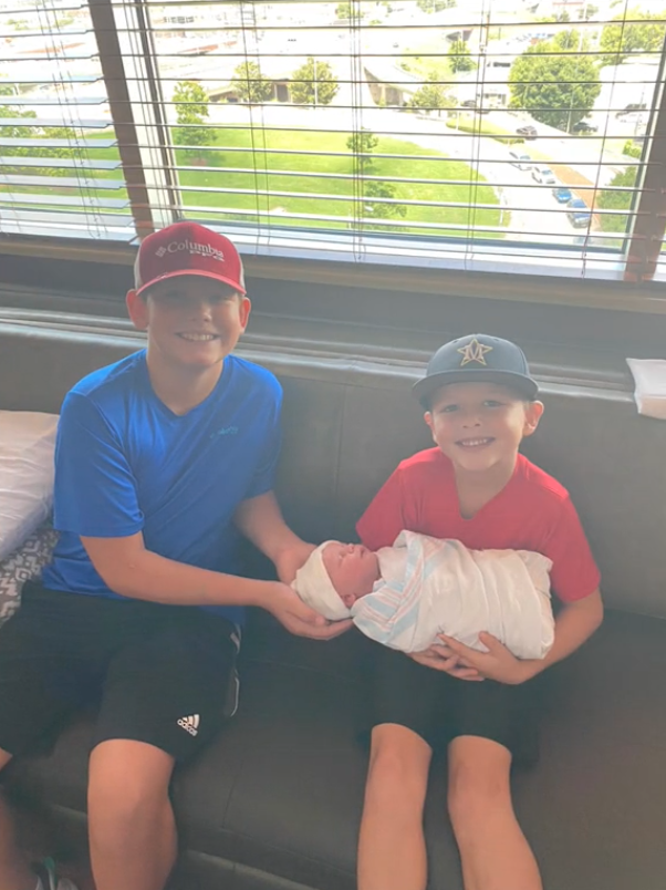 Brayden and Braxton Bosworth of Birmingham, Alabama hold their baby brother KJ after an emotional first meeting.