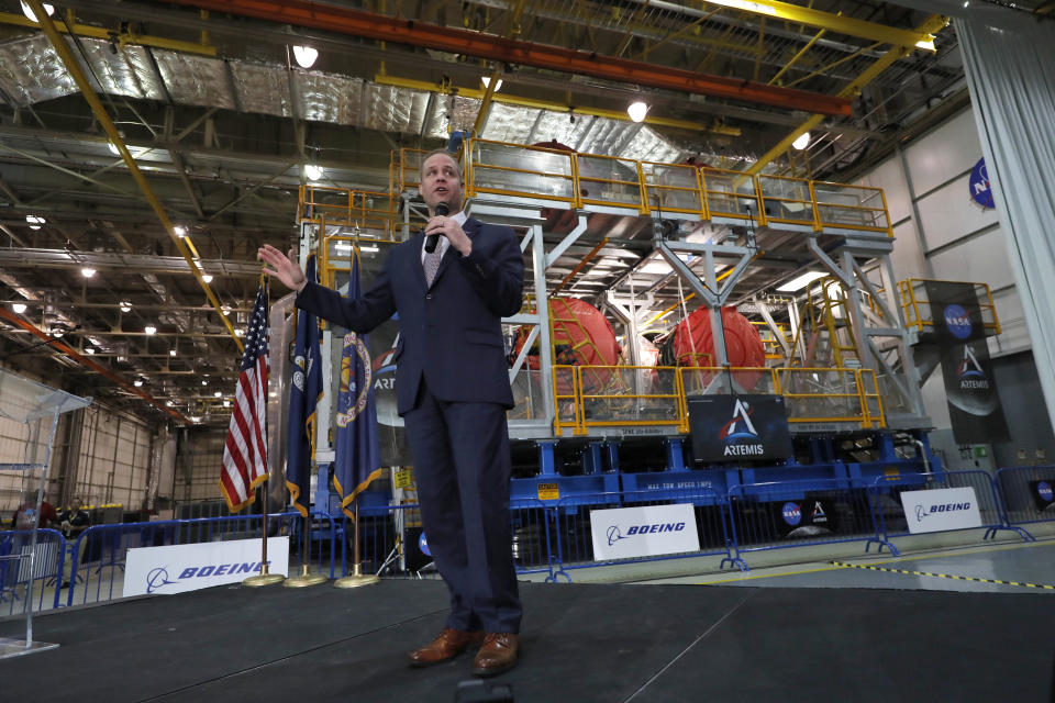 NASA administrator Jim Bridenstine speaks to a group of invited news media and social media influencers in front of NASA's Space Launch System (SLS) core stage and engines that will be used in the Artemis1 mission, at the NASA Michoud Assembly Center in New Orleans, Monday, Dec. 9, 2019. (AP Photo/Gerald Herbert)