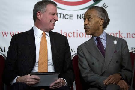 New York City Mayor Bill de Blasio (L) and civil rights activist Reverend Al Sharpton speak during a Martin Luther King day rally at the National Action Network in the Harlem section of New York January 19, 2015. REUTERS/Carlo Allegri