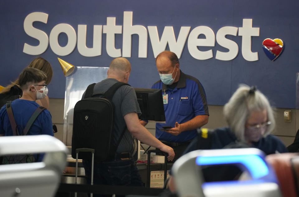 FILE - In this Wednesday, June 16, 2021, file photo, Southwest Airlines ticketing agent helps a traveller at the check-in counter at Denver International Airport in Denver. Southwest Airlines turned a profit in June without assistance from the U.S., which the company is calling a milestone in it's recovery from the pandemic. The Dallas company said Thursday, July 22 it had profit of 57 cents per share. (AP Photo/David Zalubowski, File)