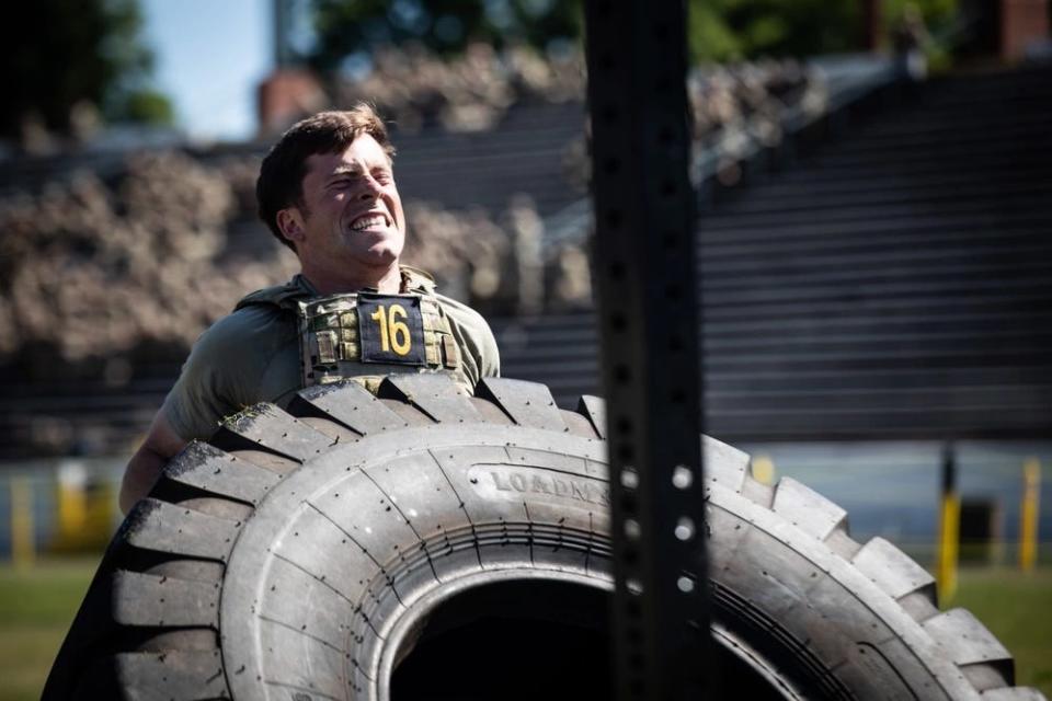 US Army first lieutenant tries to turn over a tire during the Best Ranger Competition.