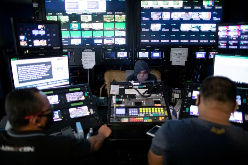 FILE PHOTO: ABS-CBN employees wearing protective face masks work in a control room at the broadcast network's headquarters, following orders by telecoms regulator to cease its operations in Quezon