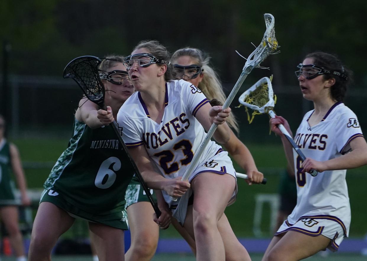 John Jay-Cross River's Jane Brennan (23) drives on Minisink's Riley Gass (6) during their 16-6 win in girls lacrosse at John Jay High School in Cross River. Friday, May 3, 2024.