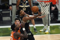 Milwaukee Bucks forward Giannis Antetokounmpo (34) goes to the basket over Phoenix Suns center Deandre Ayton (22) and guard Devin Booker during the second half of Game 6 of basketball's NBA Finals in Milwaukee, Tuesday, July 20, 2021. (AP Photo/Paul Sancya)