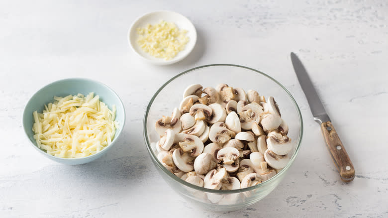 bowls of Sliced mushrooms, grated cheese, and garlic