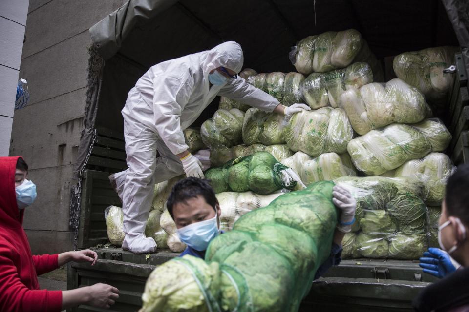 Employees wear a protective masks whilst carrying vegetables from trucks at a hospital on Feb. 10, 2020 in Wuhan, China. Flights, trains and public transport including buses, subway and ferry services have been closed for the nineteenth day. The number of those who have died from the Wuhan coronavirus, known as 2019-nCoV, in China climbed to 909. 