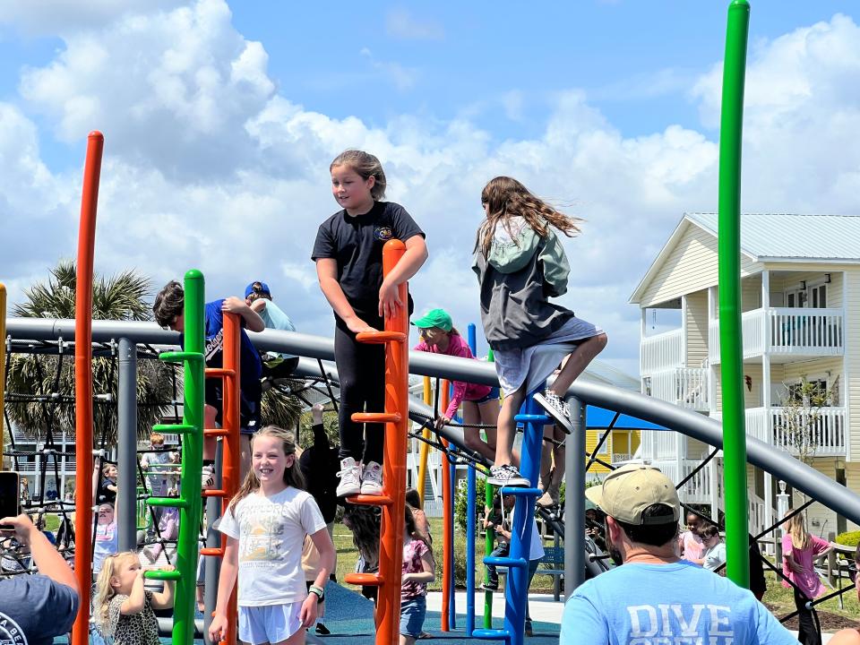 Children play on the new Brandy Myers Memorial Playground just after the ribbon cutting ceremony at on Wednesday, April 10, 2024, at Carolina Beach Lake Park.