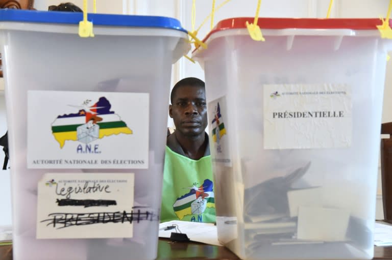 A vote officer sits next to ballot boxes at the polling station at Bangui city hall on February 14, 2016