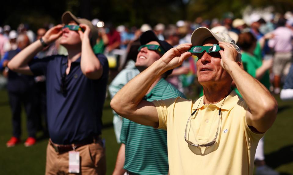 <span>Augusta patrons use glasses to view the solar eclipse before the 2024 Masters.</span><span>Photograph: Maddie Meyer/Getty Images</span>