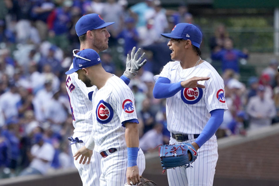 Chicago Cubs' Cody Bellinger, left, Nick Madrigal, and relief pitcher Adbert Alzolay, right, celebrate the team's win over the Milwaukee Brewers in a baseball game, Wednesday, Aug. 30, 2023, in Chicago. (AP Photo/Charles Rex Arbogast)