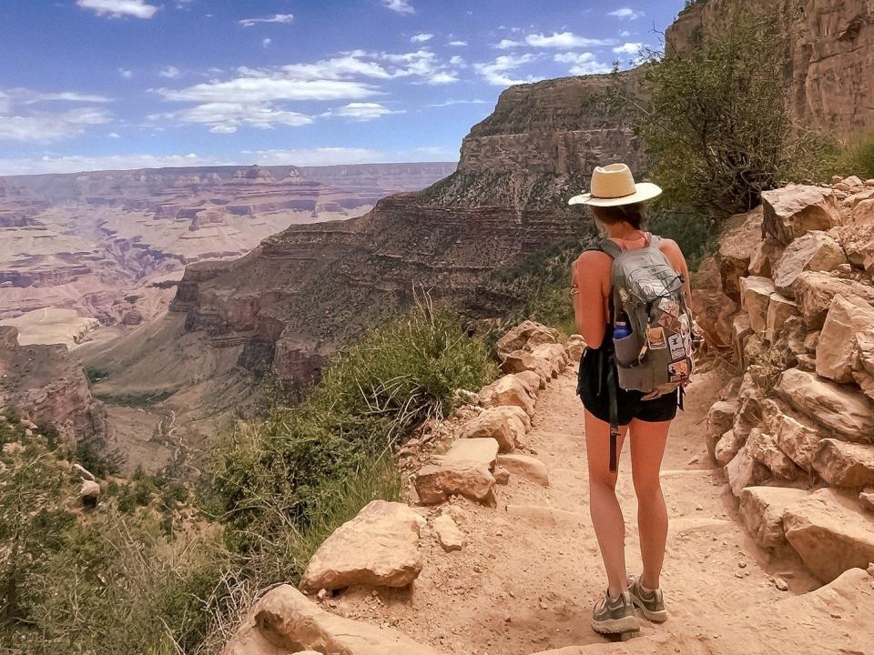 Emily walks along a trail on a sunny day in Grand Canyon National Park.