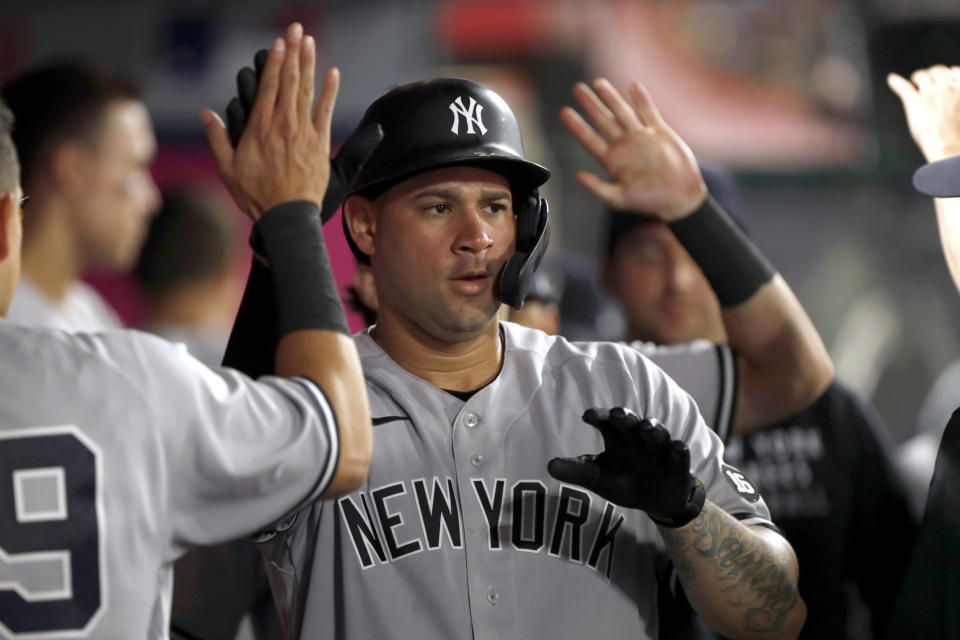 New York Yankees' Gary Sanchez is congratulated in the dugout after hitting a solo home run during the fifth inning of the team's baseball game against the Los Angeles Angels in Anaheim, Calif., Tuesday, Aug. 31, 2021. (AP Photo/Alex Gallardo)