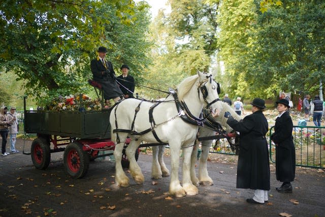 Royal Parks staff and volunteers remove floral tributes from Green Park 