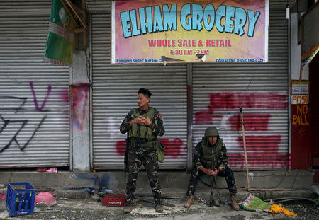 Soldiers take a break in front of a closed establishment after government troops cleared a war-torn area in Saduc proper in Marawi city, southern Philippines October 22, 2017. REUTERS/Romeo Ranoco