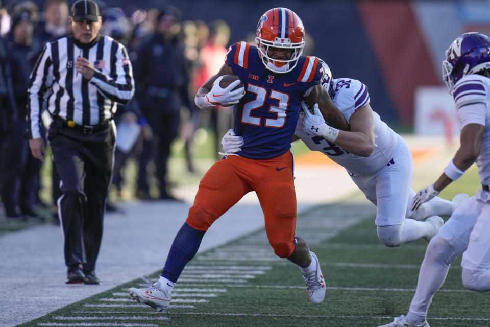 Illinois running back Reggie Love III (23) is forced out of bounds by Illinois defensive back CJ Bufkin (32) during the first half of an NCAA college football game Saturday, Nov. 25, 2023, in Champaign, Ill. (AP Photo/Erin Hooley)